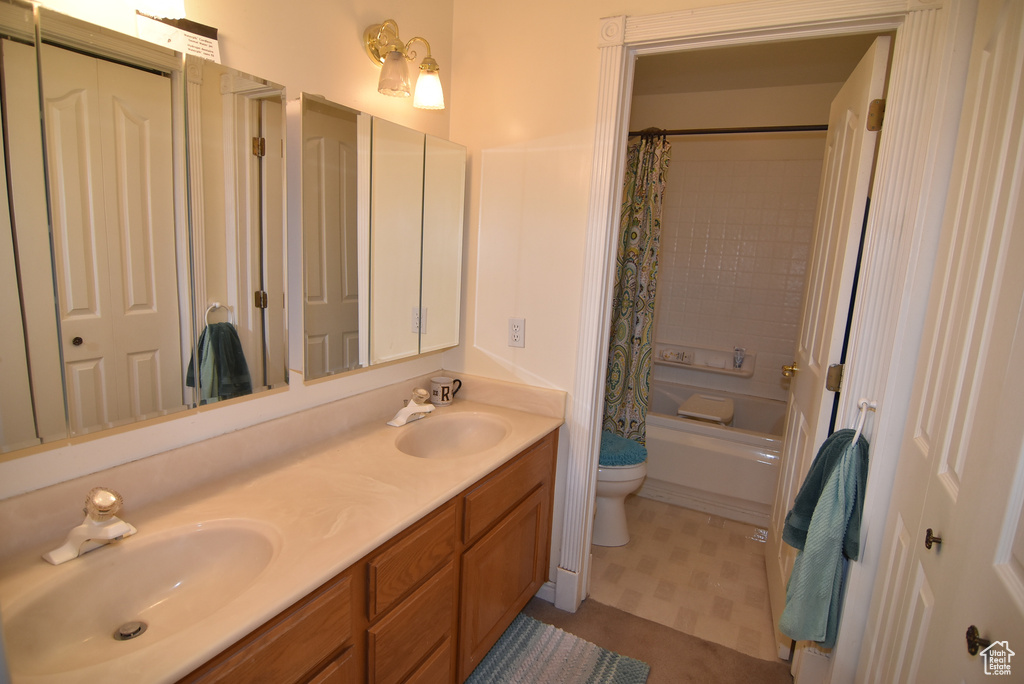 Full bathroom featuring double vanity, toilet, and shower / bathtub combination with curtain