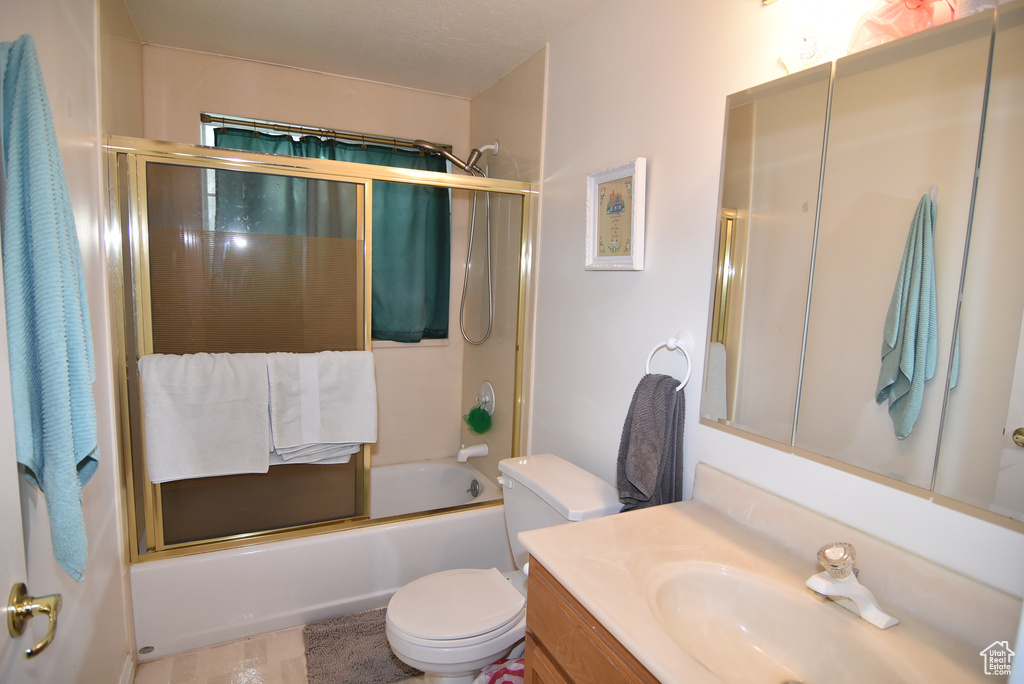 Full bath featuring toilet, vanity, and enclosed tub / shower combo