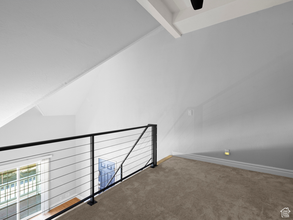 Bonus room with carpet, baseboards, lofted ceiling with beams, and a ceiling fan