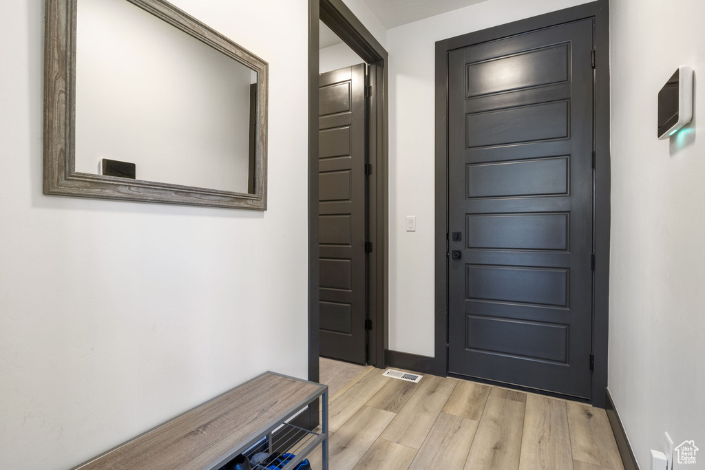 Entrance foyer featuring baseboards, light wood-type flooring, and visible vents