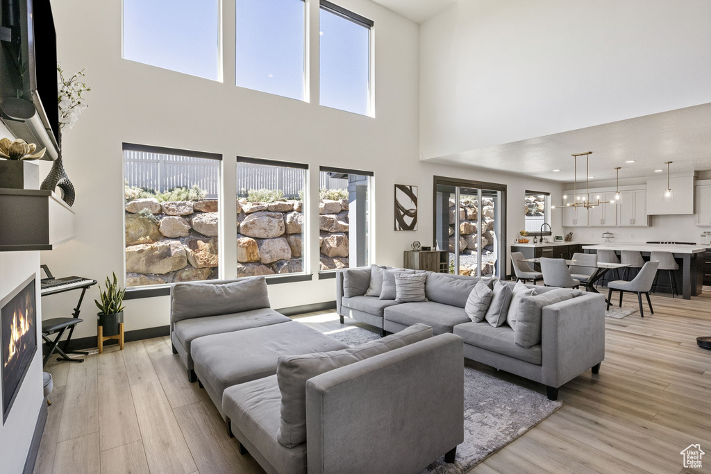 Living room featuring a notable chandelier, a high ceiling, and a wealth of natural light