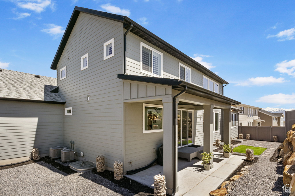 Rear view of house featuring fence and a patio