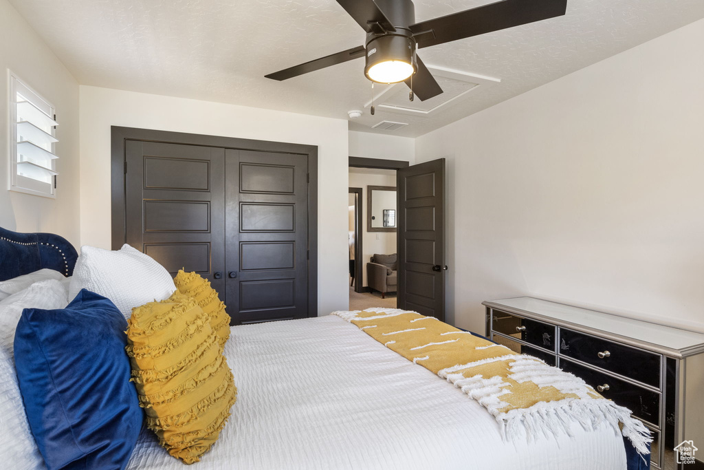 Carpeted bedroom with a closet, ceiling fan, and visible vents