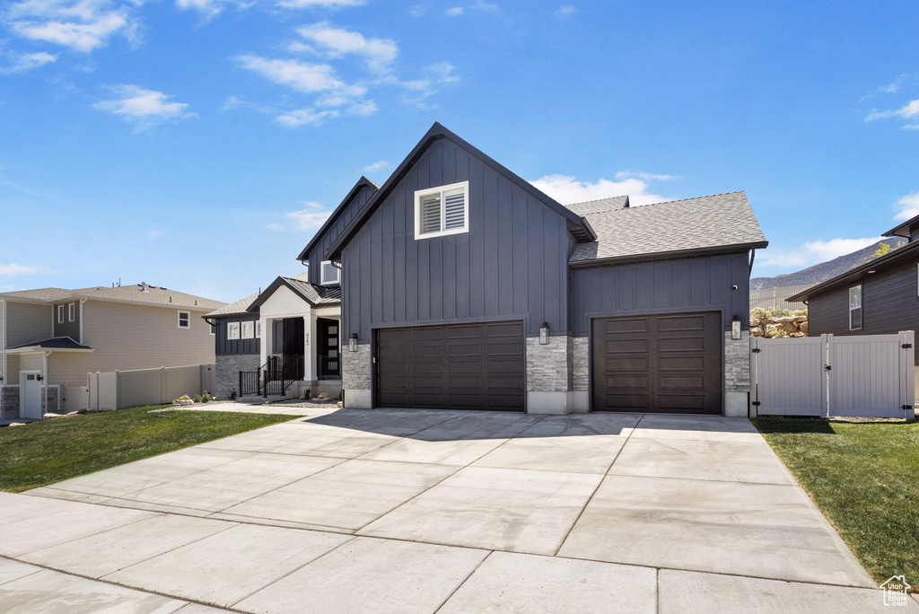 Modern inspired farmhouse featuring fence, a garage, board and batten siding, a gate, and driveway