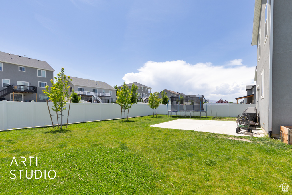View of yard with a trampoline, a residential view, and a patio
