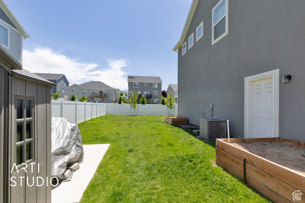 View of yard with cooling unit, a residential view, and a garden