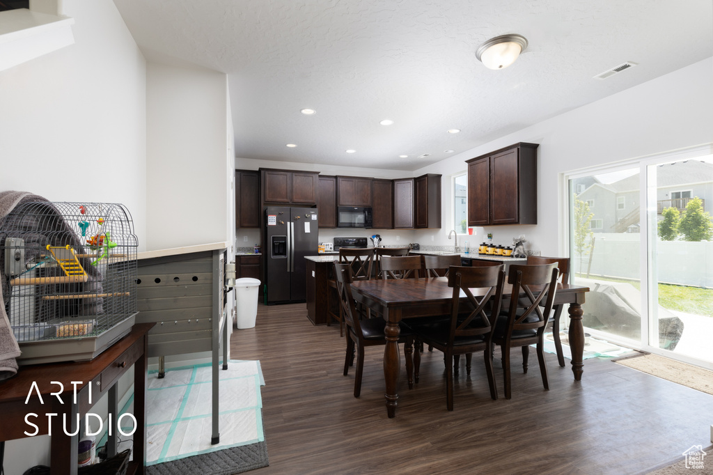Dining area featuring dark wood finished floors and recessed lighting