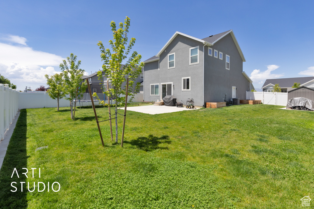Back of house with a trampoline, a patio, stucco siding, and cooling unit