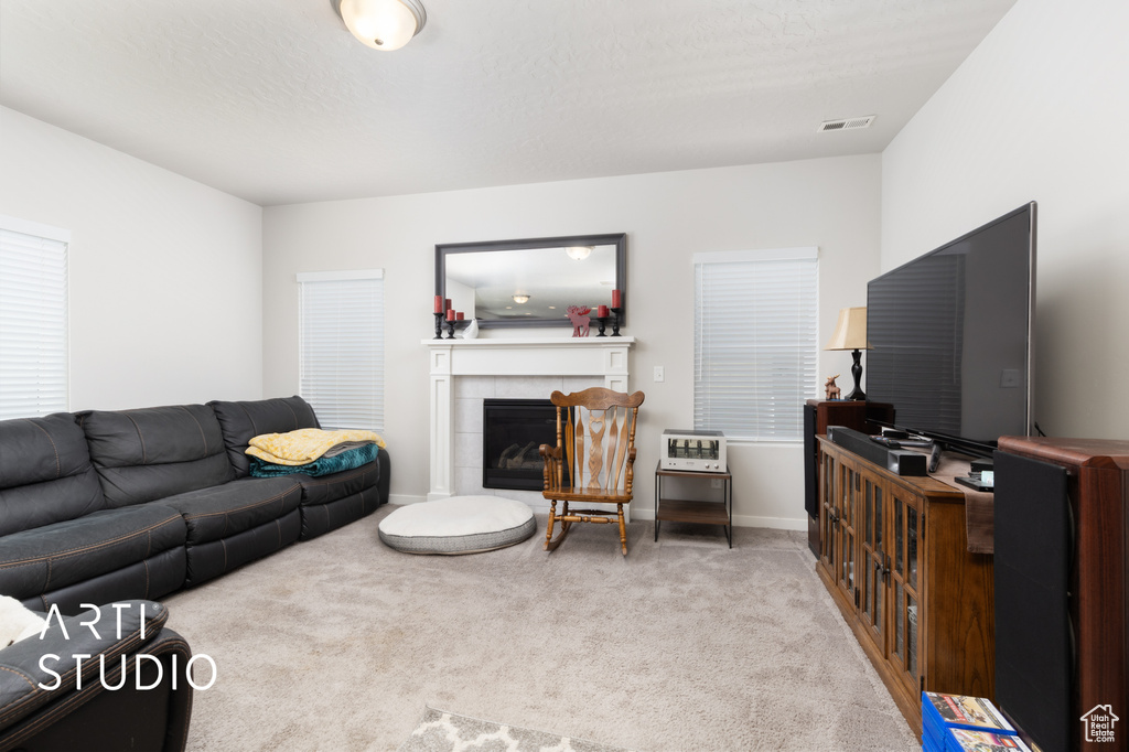 Carpeted living room with a fireplace and baseboards