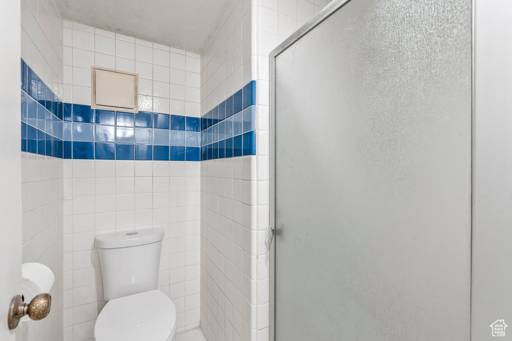 Full bathroom featuring a shower stall and toilet