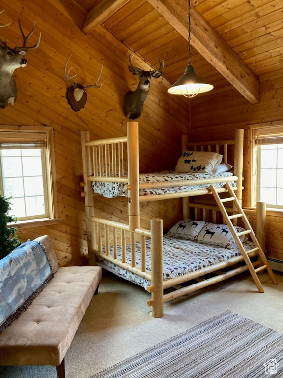 Carpeted bedroom with wooden walls, wood ceiling, and lofted ceiling with beams