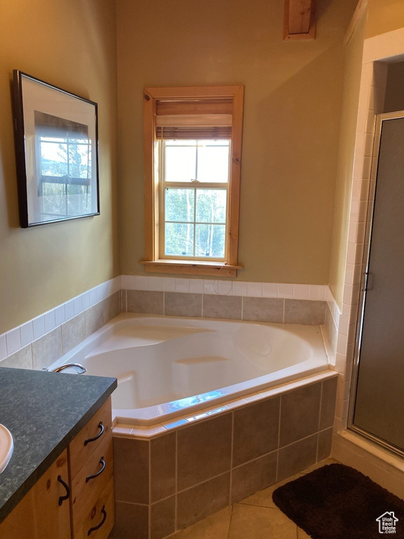 Full bath featuring a stall shower, tile patterned floors, vanity, and a bath