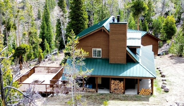 Back of property featuring a chimney and metal roof