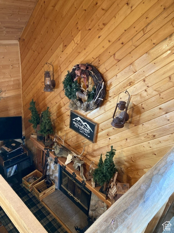 Details with wooden walls, wood ceiling, and a stone fireplace