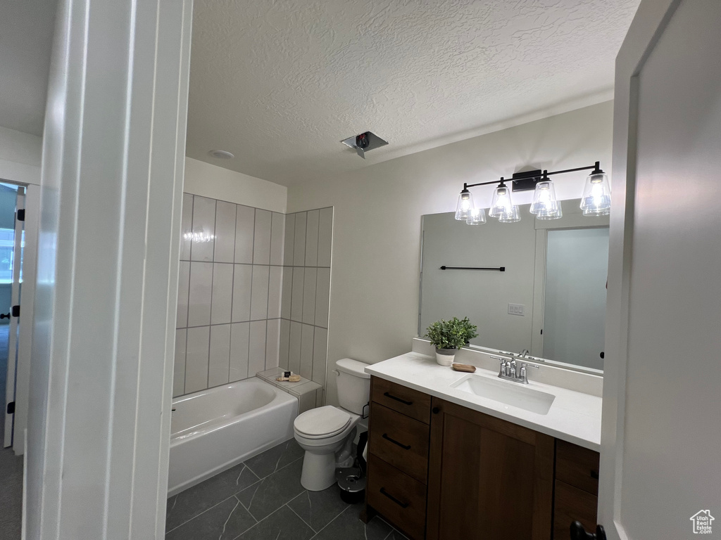Full bath featuring vanity, a textured ceiling, and tile patterned flooring