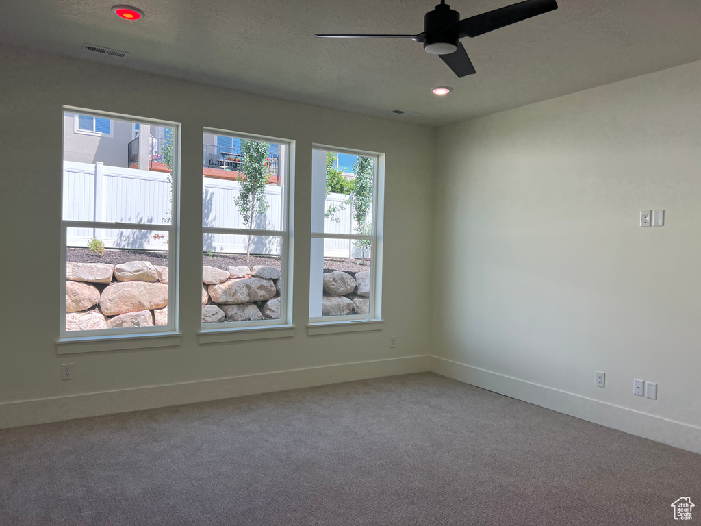 Carpeted spare room with a ceiling fan and recessed lighting