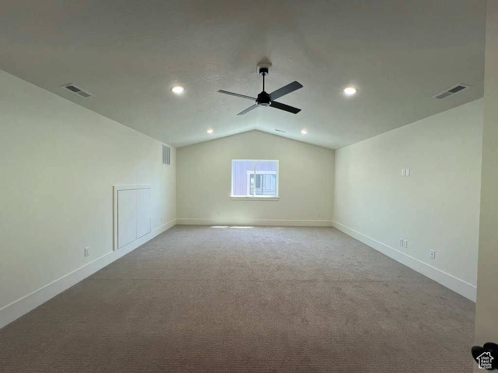 Carpeted spare room with a ceiling fan, lofted ceiling, and recessed lighting