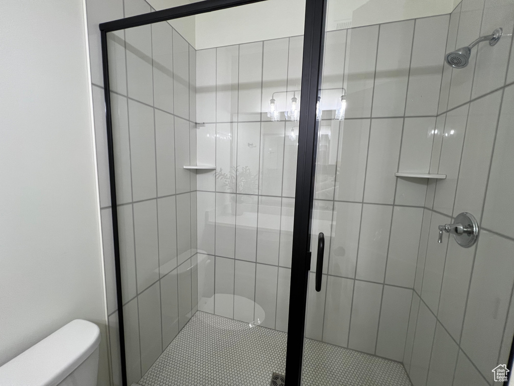 Full bath featuring toilet and a stall shower