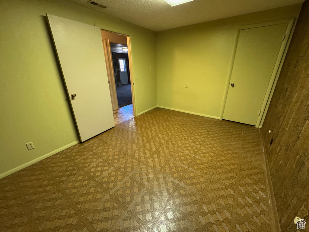 Empty room with baseboards, visible vents, and tile patterned floors