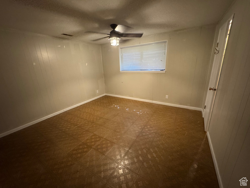 Unfurnished bedroom featuring tile patterned floors, a textured ceiling, baseboards, and a ceiling fan