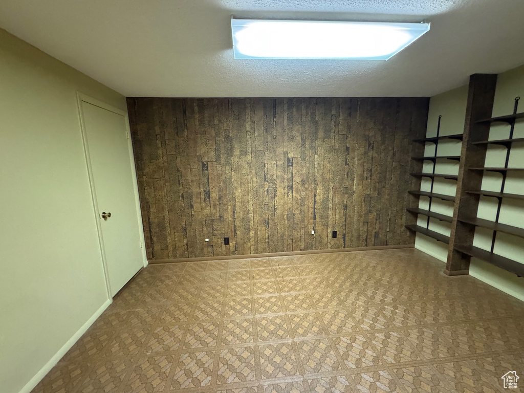 Finished basement featuring baseboards and wooden walls