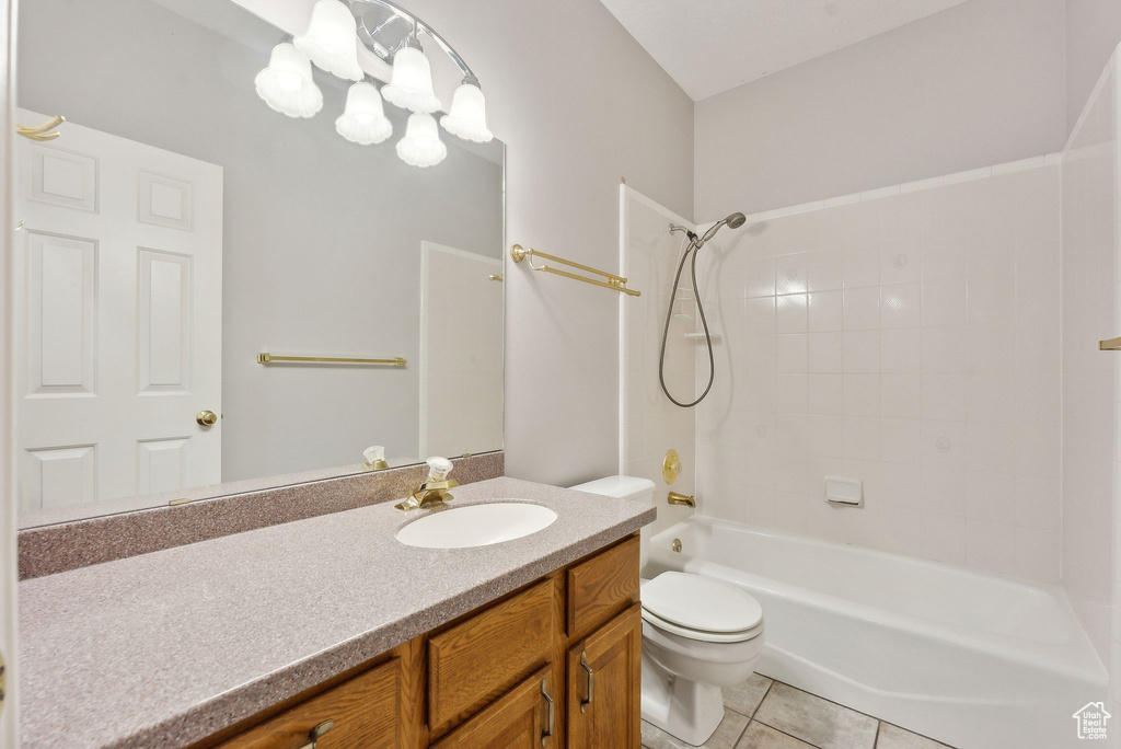 Bathroom featuring tile patterned flooring, toilet,  shower combination, and vanity