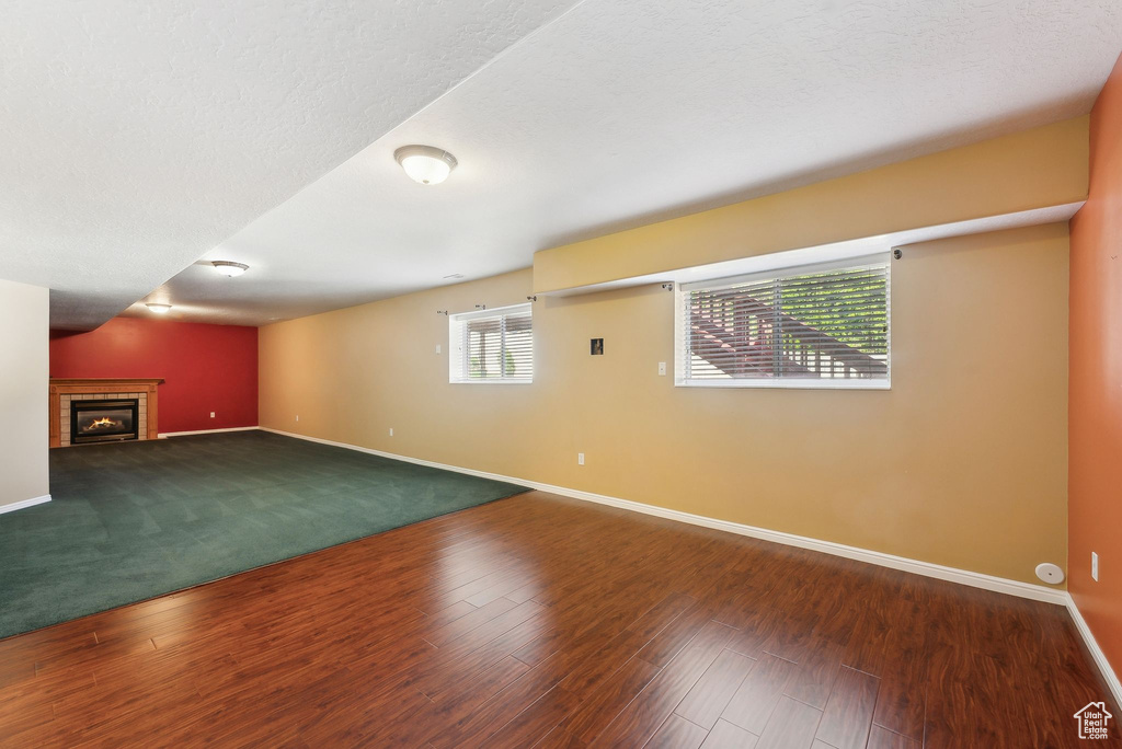 Basement with wood finished floors, baseboards, and a fireplace