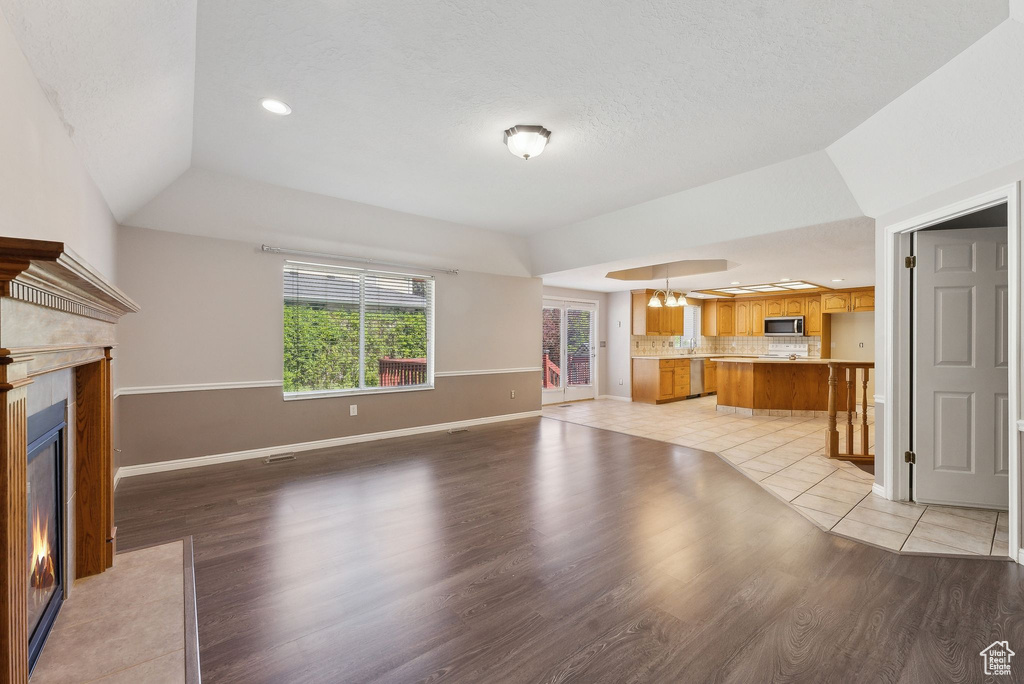 Unfurnished living room featuring light wood-style flooring, baseboards, and a fireplace with flush hearth