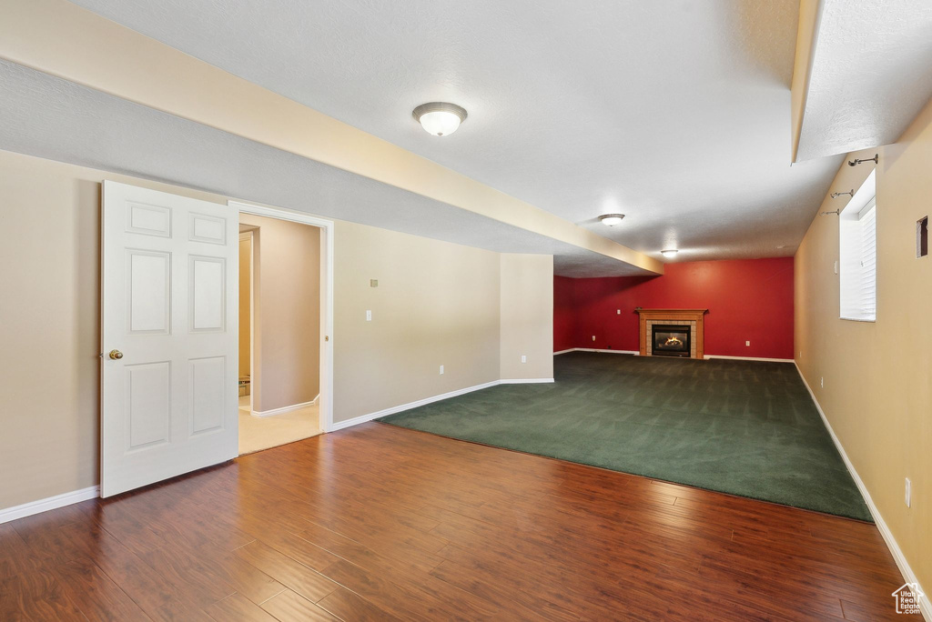 Below grade area featuring baseboards, a fireplace, and wood finished floors