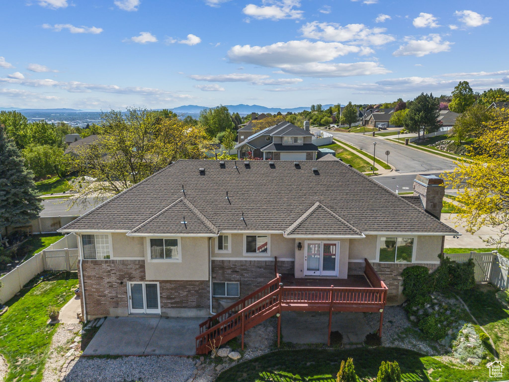 Back of property featuring stairs, a patio, stucco siding, a fenced backyard, and a deck with mountain view