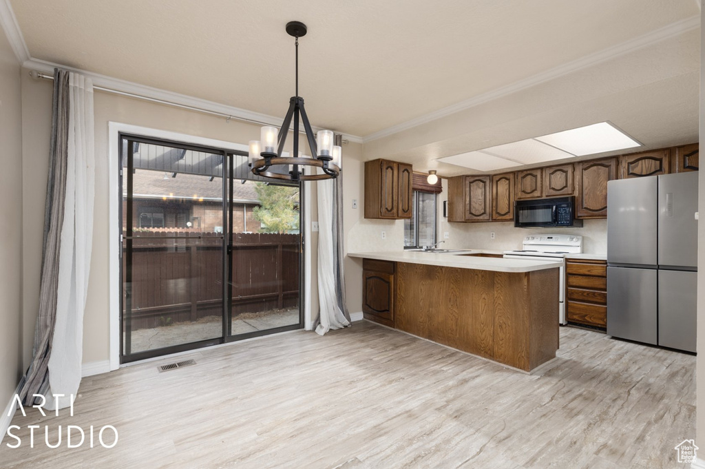 Kitchen with freestanding refrigerator, visible vents, light wood-style flooring, black microwave, and white electric range