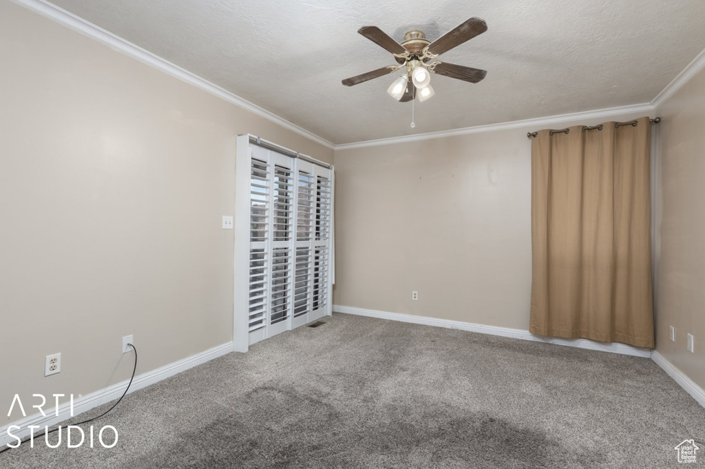 Unfurnished room with a ceiling fan, ornamental molding, carpet flooring, and baseboards