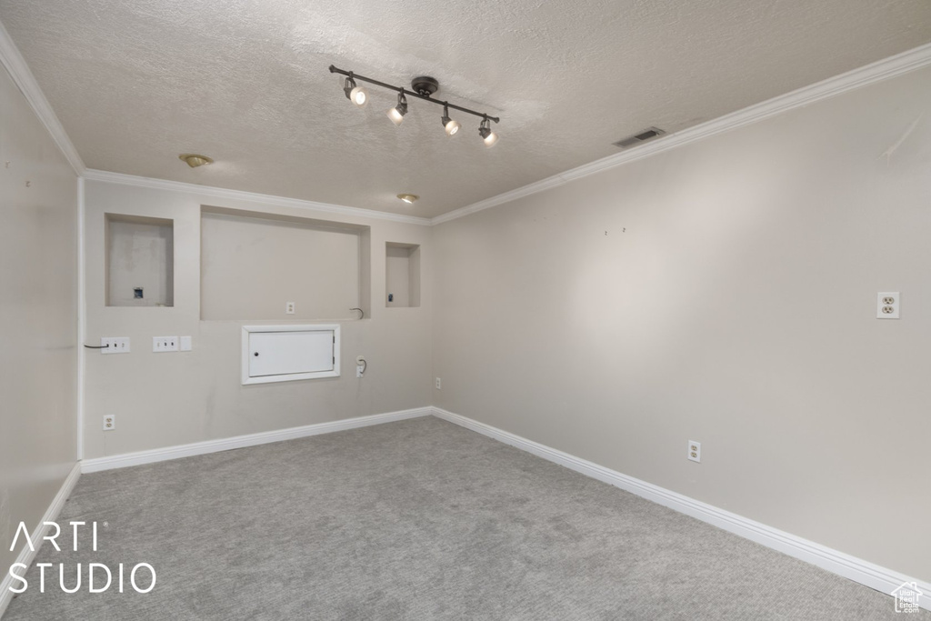 Carpeted spare room featuring crown molding, a textured ceiling, visible vents, and baseboards
