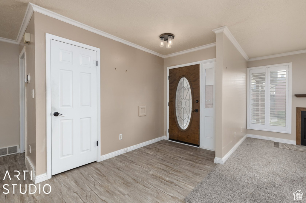Entryway featuring crown molding, visible vents, and baseboards