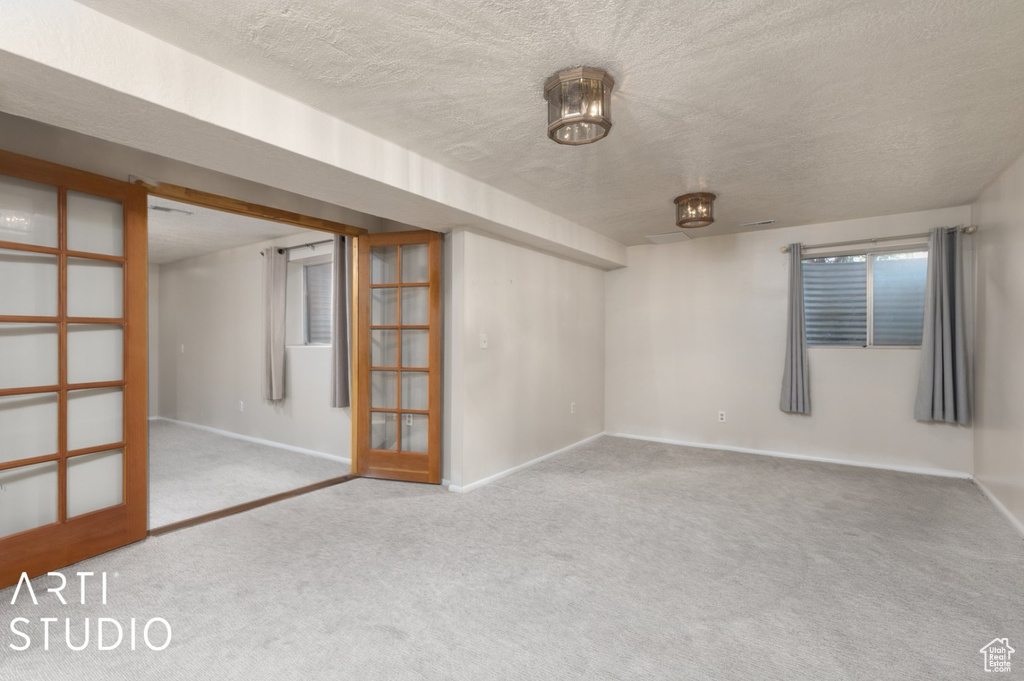 Carpeted spare room with baseboards and a textured ceiling