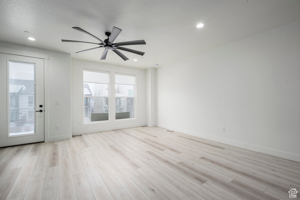 Empty room with light wood finished floors, baseboards, and recessed lighting