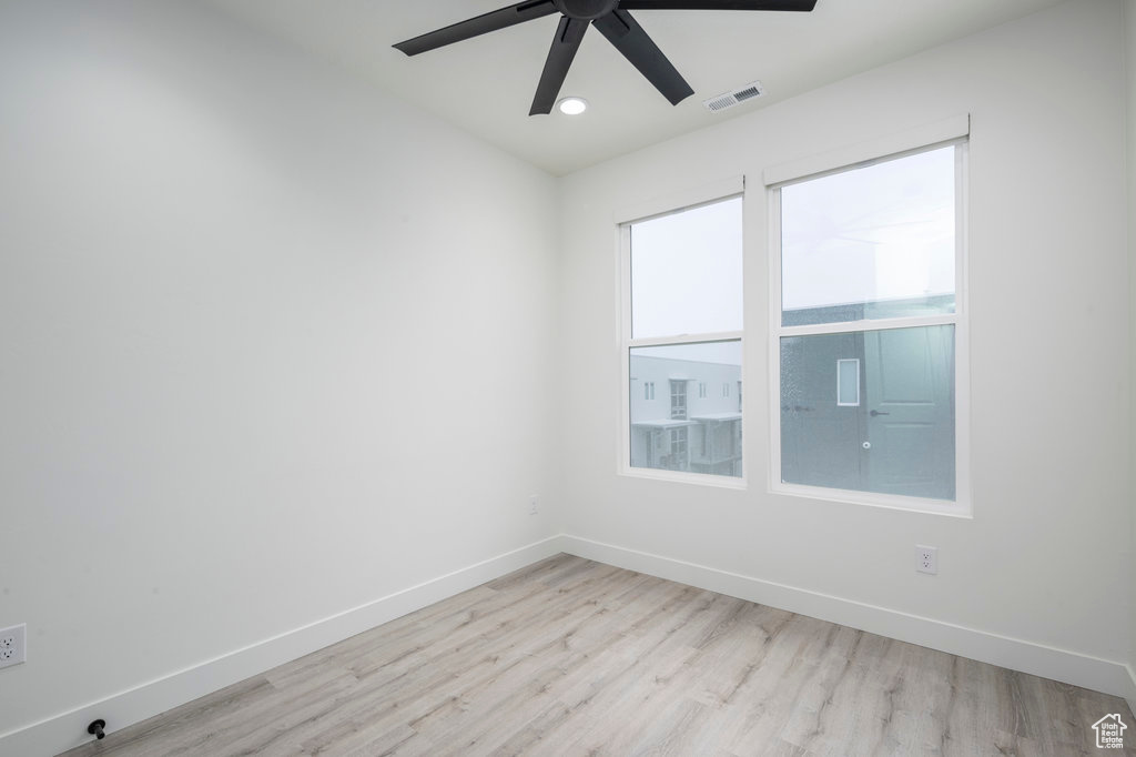 Spare room featuring wood finished floors, visible vents, recessed lighting, a ceiling fan, and baseboards