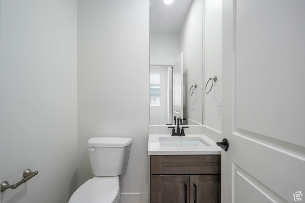 Half bathroom featuring vanity and toilet