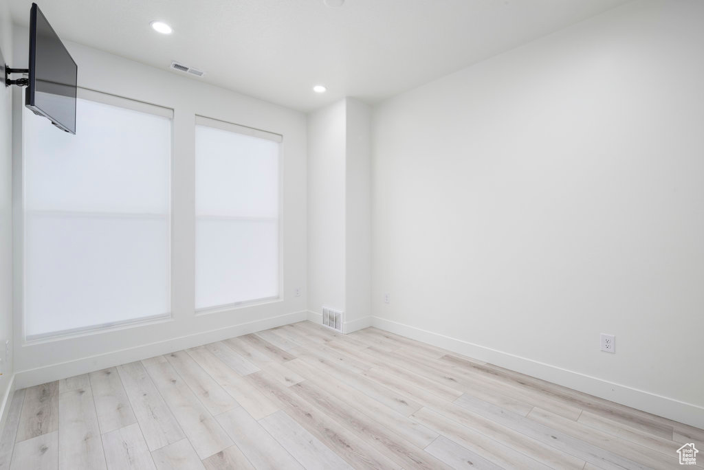 Unfurnished room featuring recessed lighting, baseboards, visible vents, and wood finished floors