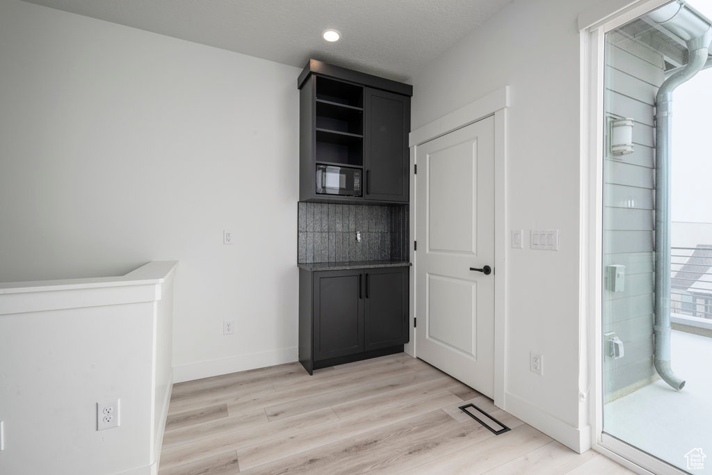 Interior space with baseboards, light wood-type flooring, visible vents, and recessed lighting