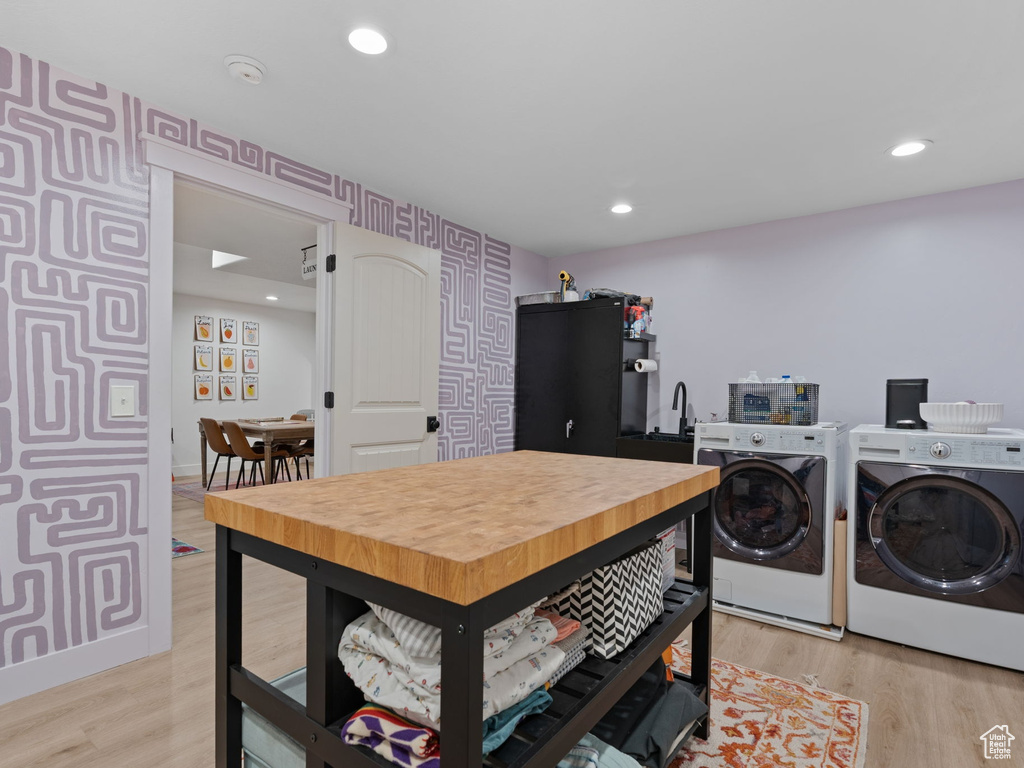 Laundry room with recessed lighting, washer and clothes dryer, and light wood-style flooring