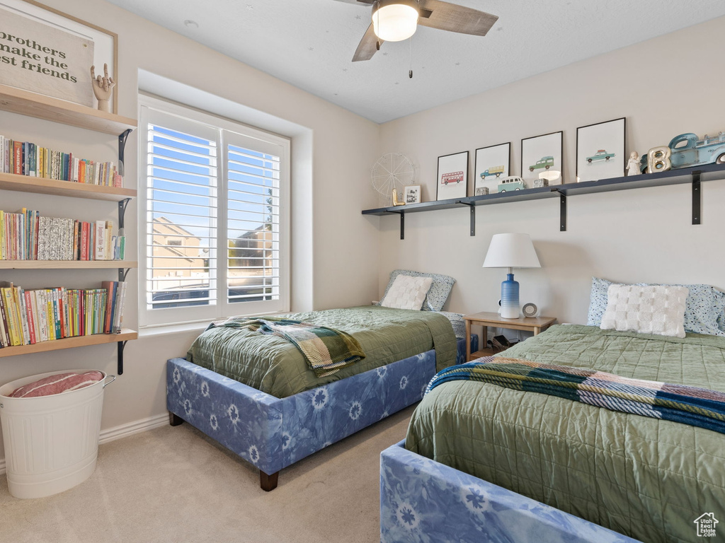 Carpeted bedroom featuring baseboards and a ceiling fan