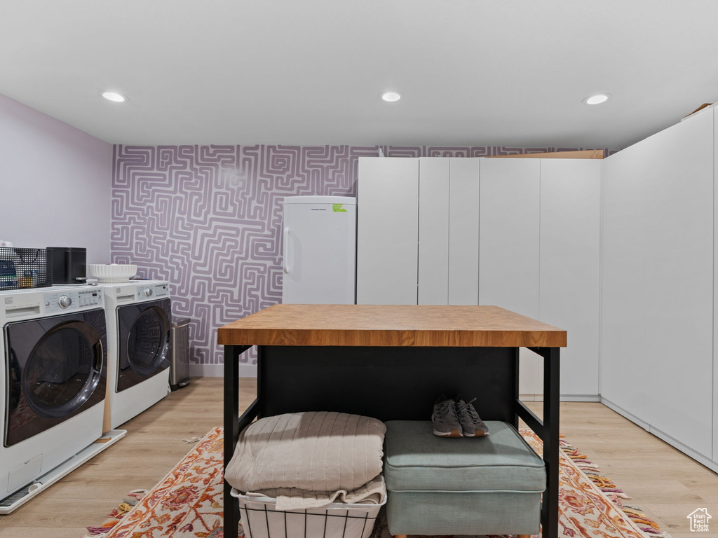 Laundry room featuring recessed lighting, an accent wall, wallpapered walls, and independent washer and dryer