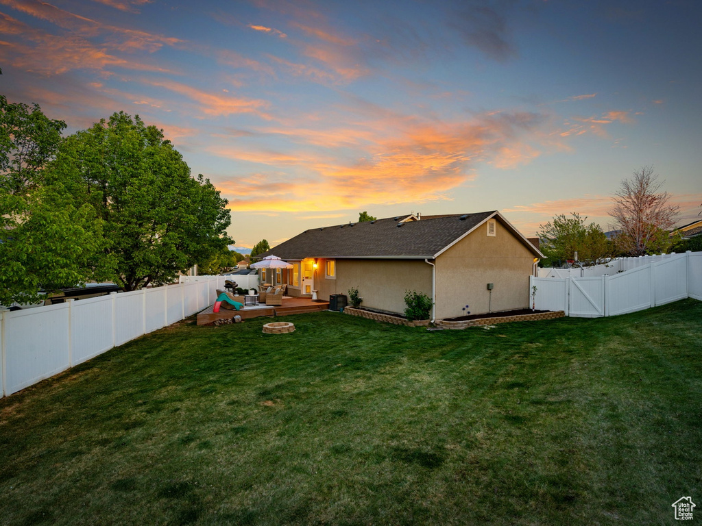 View of yard featuring a fenced backyard, a fire pit, and a wooden deck