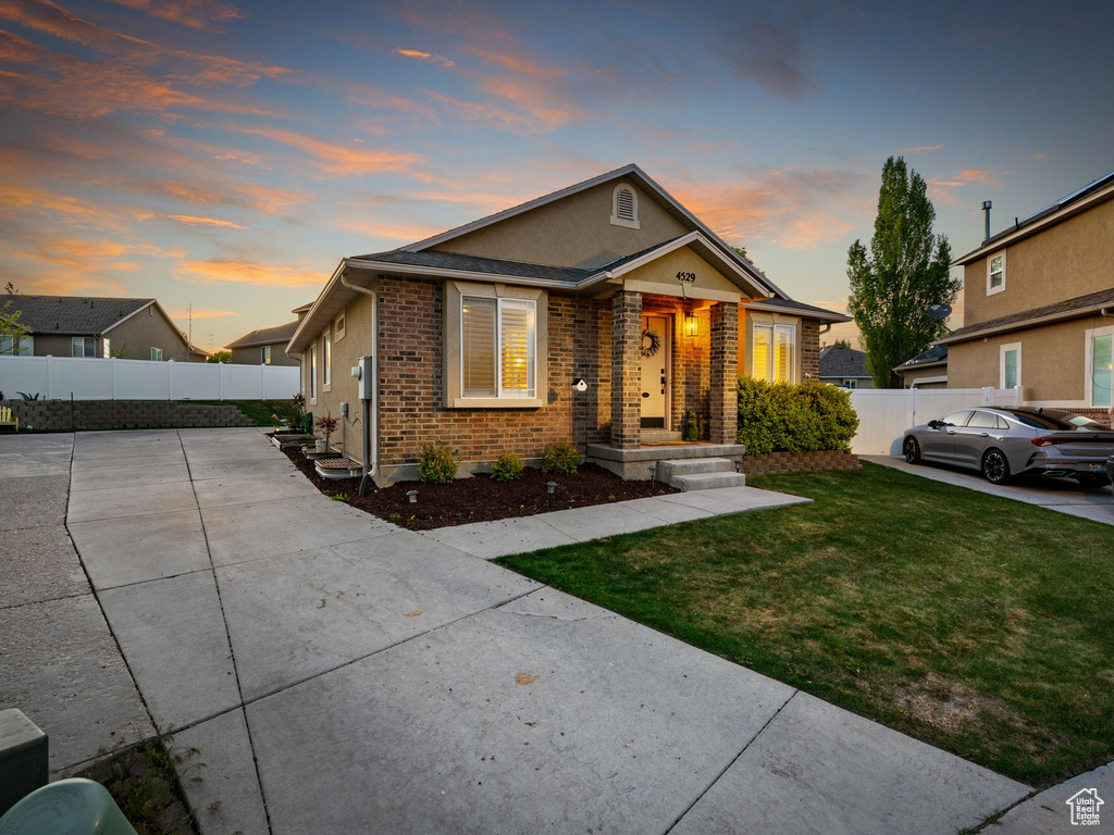 Bungalow featuring brick siding, fence, and a front yard