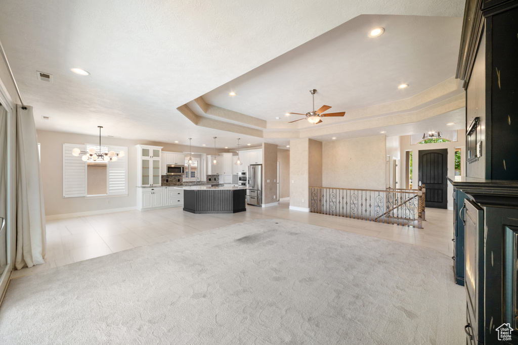 Unfurnished living room with visible vents, baseboards, ceiling fan with notable chandelier, and recessed lighting