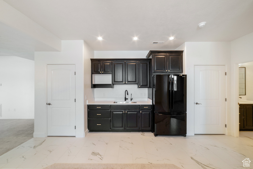 Kitchen with a sink, freestanding refrigerator, visible vents, light countertops, and marble finish floor