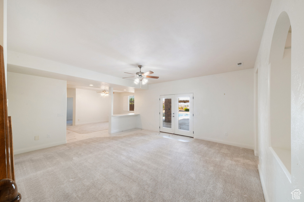 Unfurnished room featuring baseboards, french doors, ceiling fan, and light colored carpet