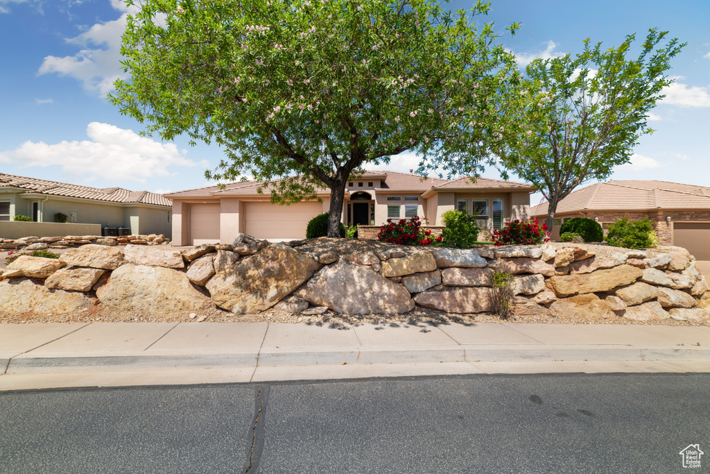 Ranch-style home with a garage and stucco siding