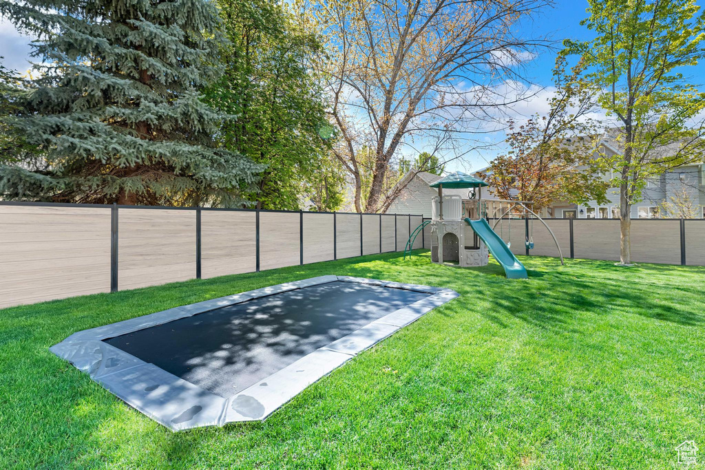 View of yard with a fenced backyard and a playground